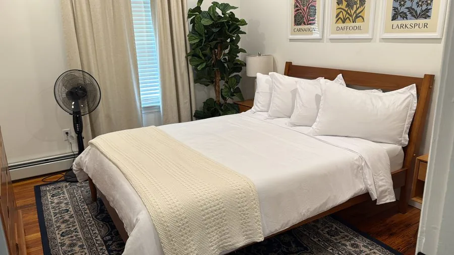Freshly made guest bed with crisp white linens, ready to welcome Airbnb guests