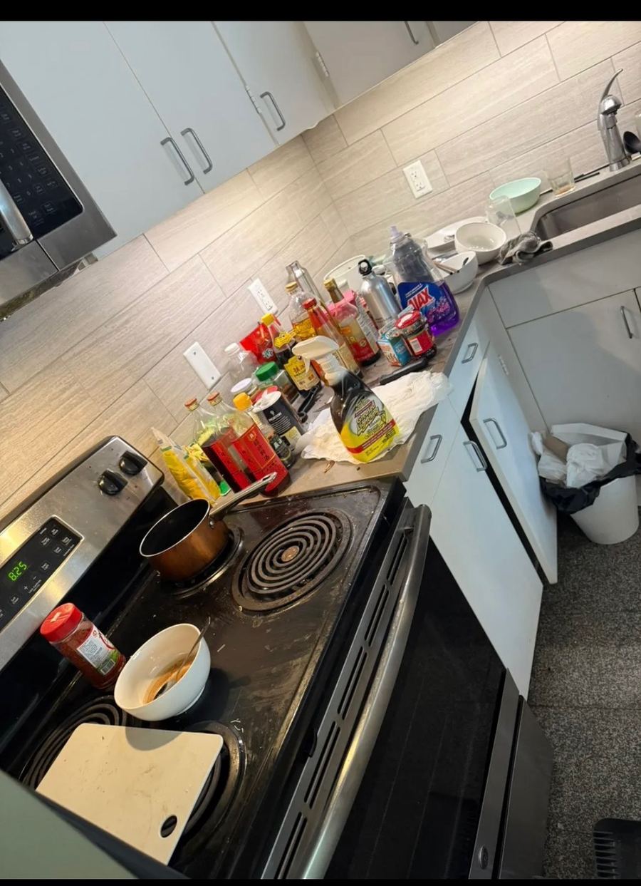 Cluttered kitchen counters and stovetop before cleaning